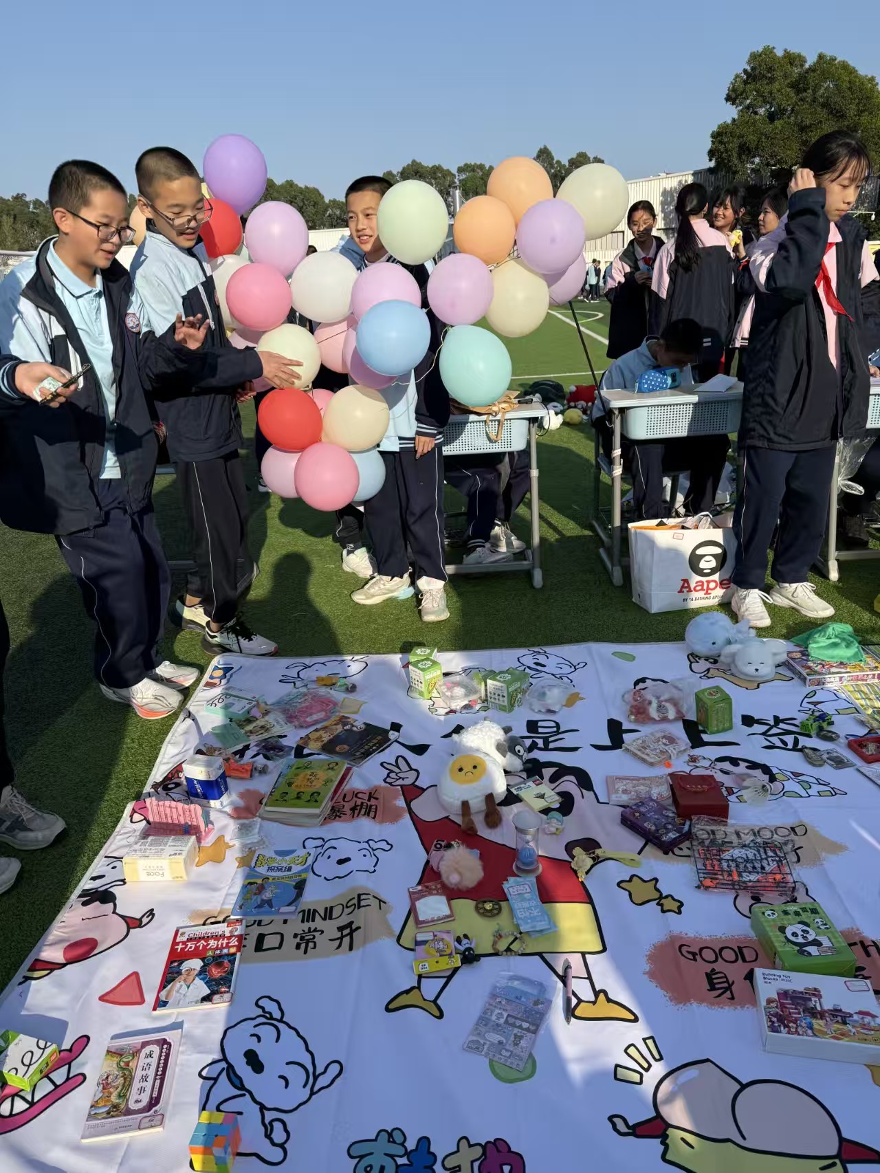 同学们在摊位前交流和挑选物品